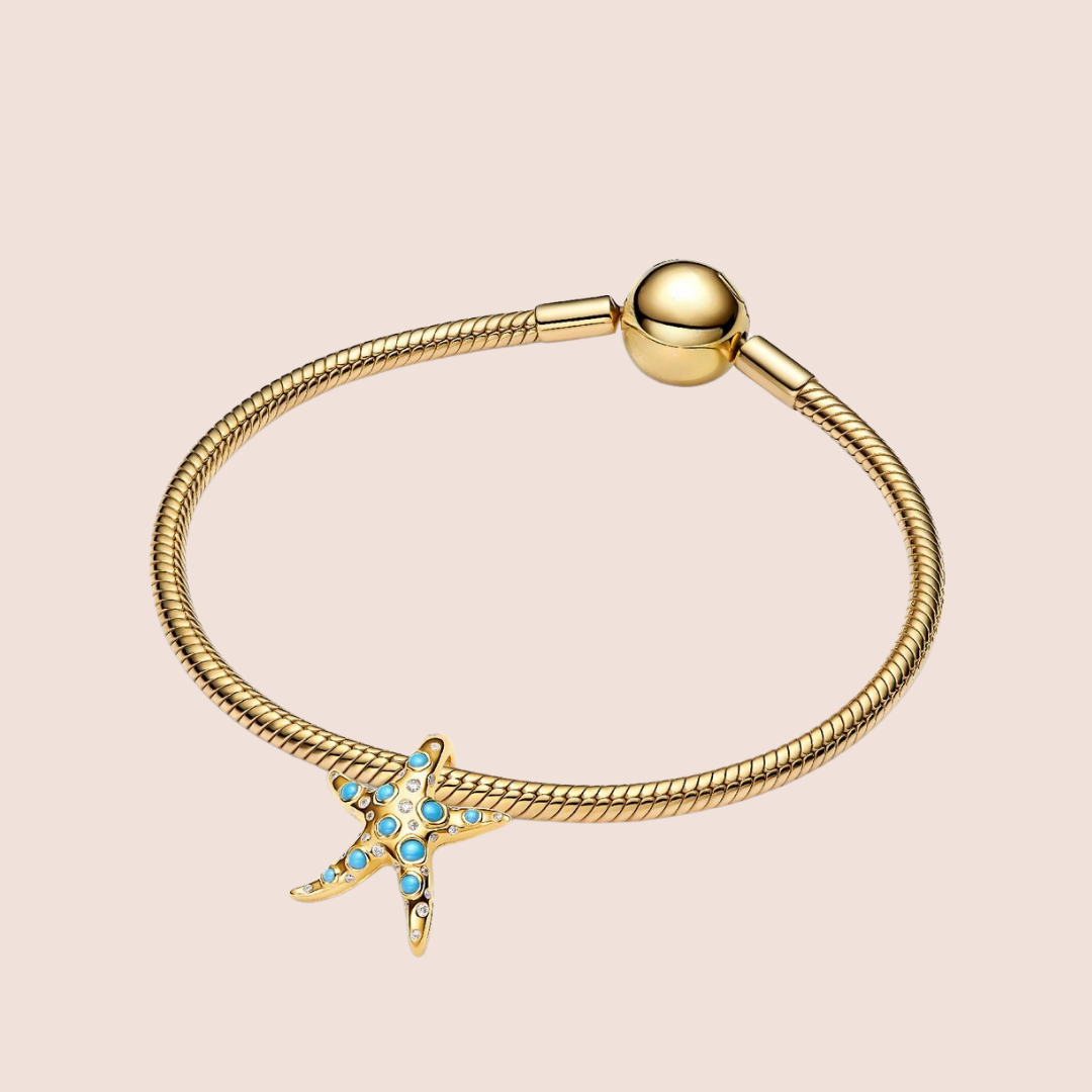 Charm estrella de mar dorada grande con piedras azules